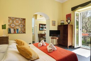 Une chambre d’hôtel avec un lit, une télévision, une bibliothèque et une vue sur l’extérieur.
