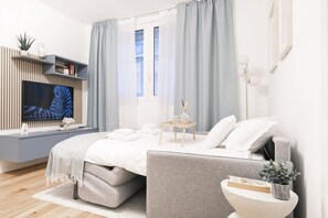 Een moderne slaapkamer met een bed, nachtkastje en een televisie op een wandplank.