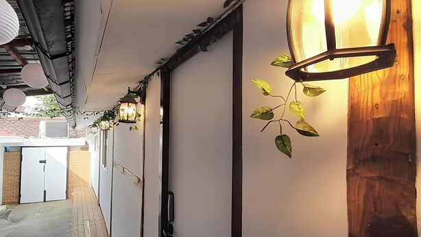 A corridor with a wooden floor, white walls, and hanging lanterns. - Hyehwa 1937 (Hanok), a traditional Korean house built in 1937 (Seongbuk District)