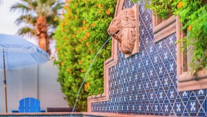 A pool with a decorative wall featuring a lion head and blue patterned tiles. - Timeless Elegance: Historic Estate w/ Pool, Hot Tub + Putting Green (Phoenix)