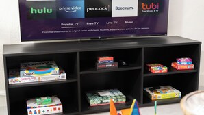 A TV displaying various streaming services and a shelf with board games.