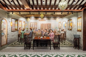 Un comedor de estilo tradicional con mesas y sillas de madera, faroles decorativos y suelo de baldosas.