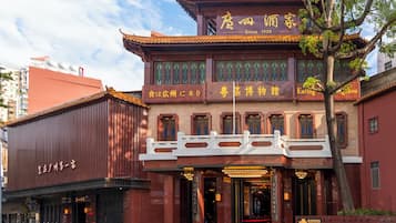A traditional building with a red facade, a white balcony, and a sign indicating it has been established since 1935.