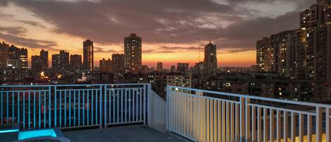 Una terrazza sul tetto con la skyline della città al crepuscolo.