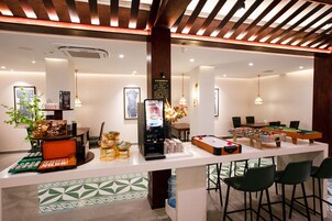 Una zona de bar con mesa de fútbol de mesa, una máquina de café y un tablero de menú.