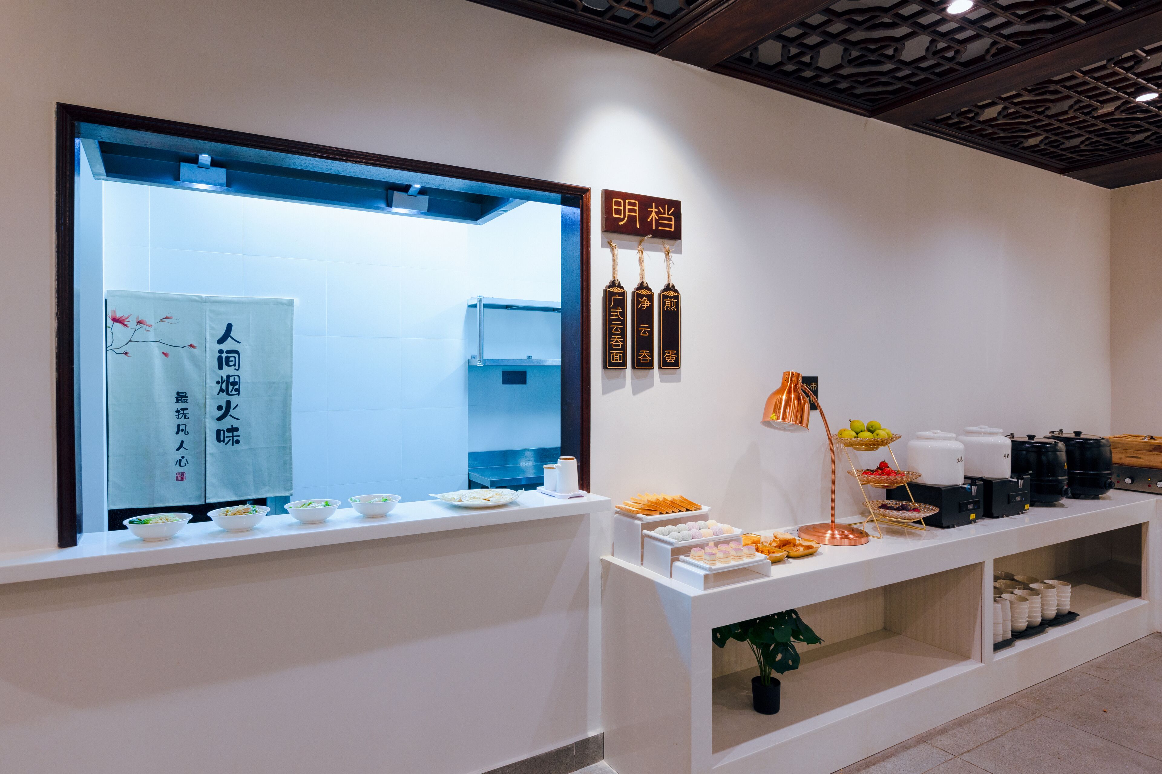 A buffet setup with various food items and a large mirror.