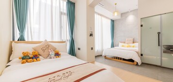 Una camera d'albergo con un letto grande, un letto più piccolo e un armadio.
