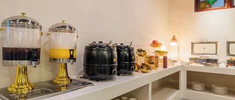 Ein Buffet mit Getränkespendern, einem Computer und einer dekorativen Vase.
