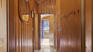 A wooden hallway with a door leading to a room with a view of a snowy landscape. - Beautiful alpine apartment 5 minutes from Saas-Fee (Saas-Grund)