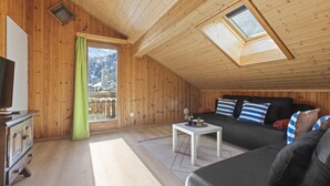 A cozy wooden interior with a sofa, a small table, and a TV. - Beautiful alpine apartment 5 minutes from Saas-Fee (Saas-Grund)