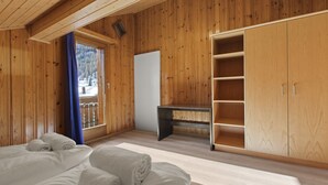 A wooden room with a bed, a desk, and a wardrobe. - Beautiful alpine apartment 5 minutes from Saas-Fee (Saas-Grund)