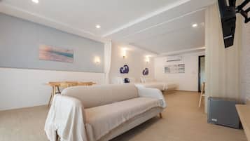 Una habitación de hotel con una cama grande, un escritorio y una televisión.