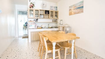A kitchen with a wooden table and chairs, a microwave, and a sink.