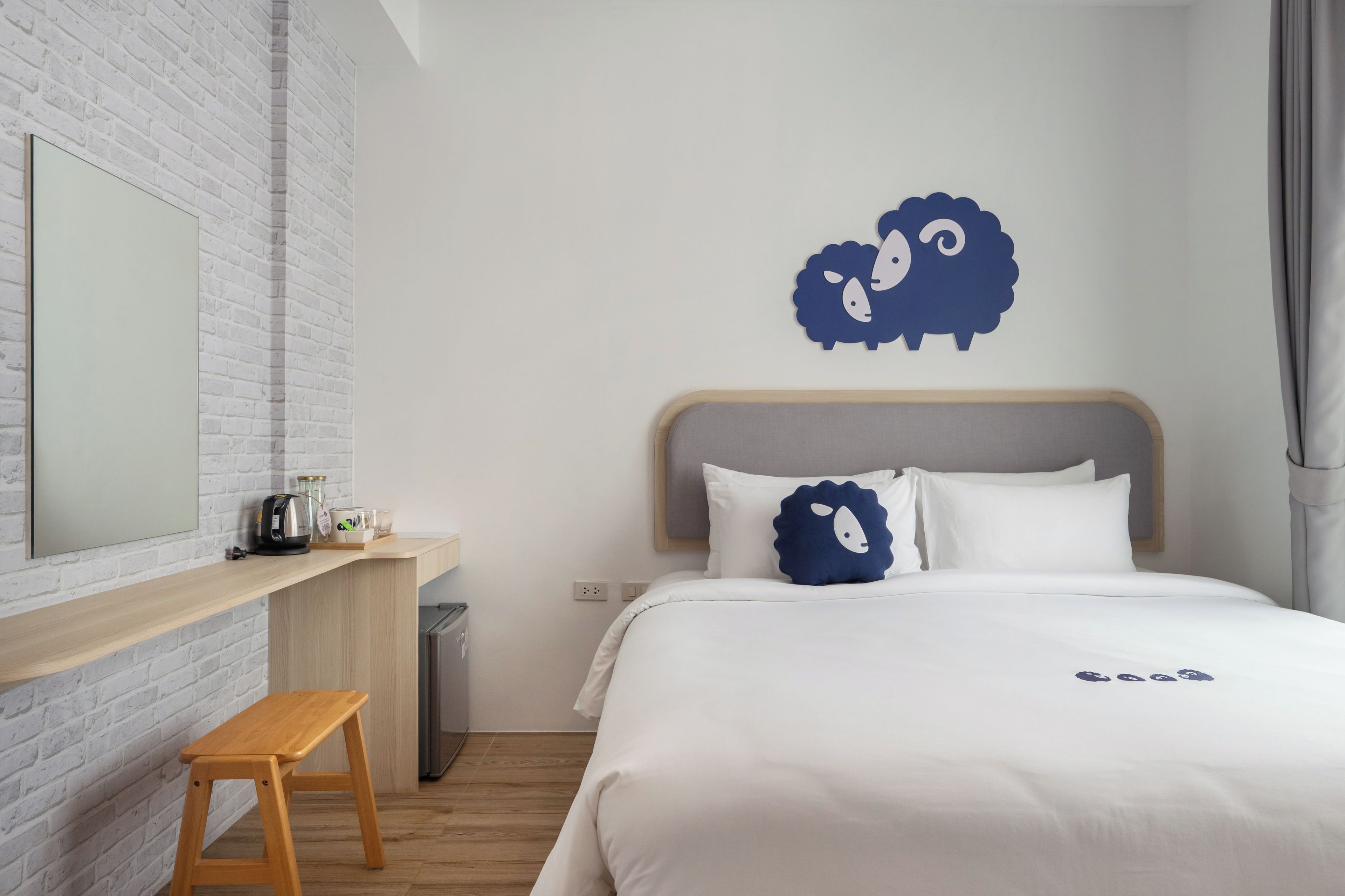 Une chambre à coucher comprenant un lit, un banc en bois, une étagère fixée au mur et un élément décoratif mural.