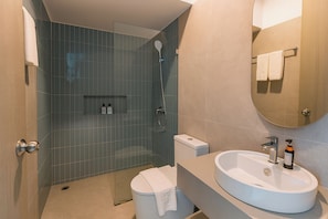 Une salle de bain moderne équipée d’une douche, de toilettes et d’un lavabo.