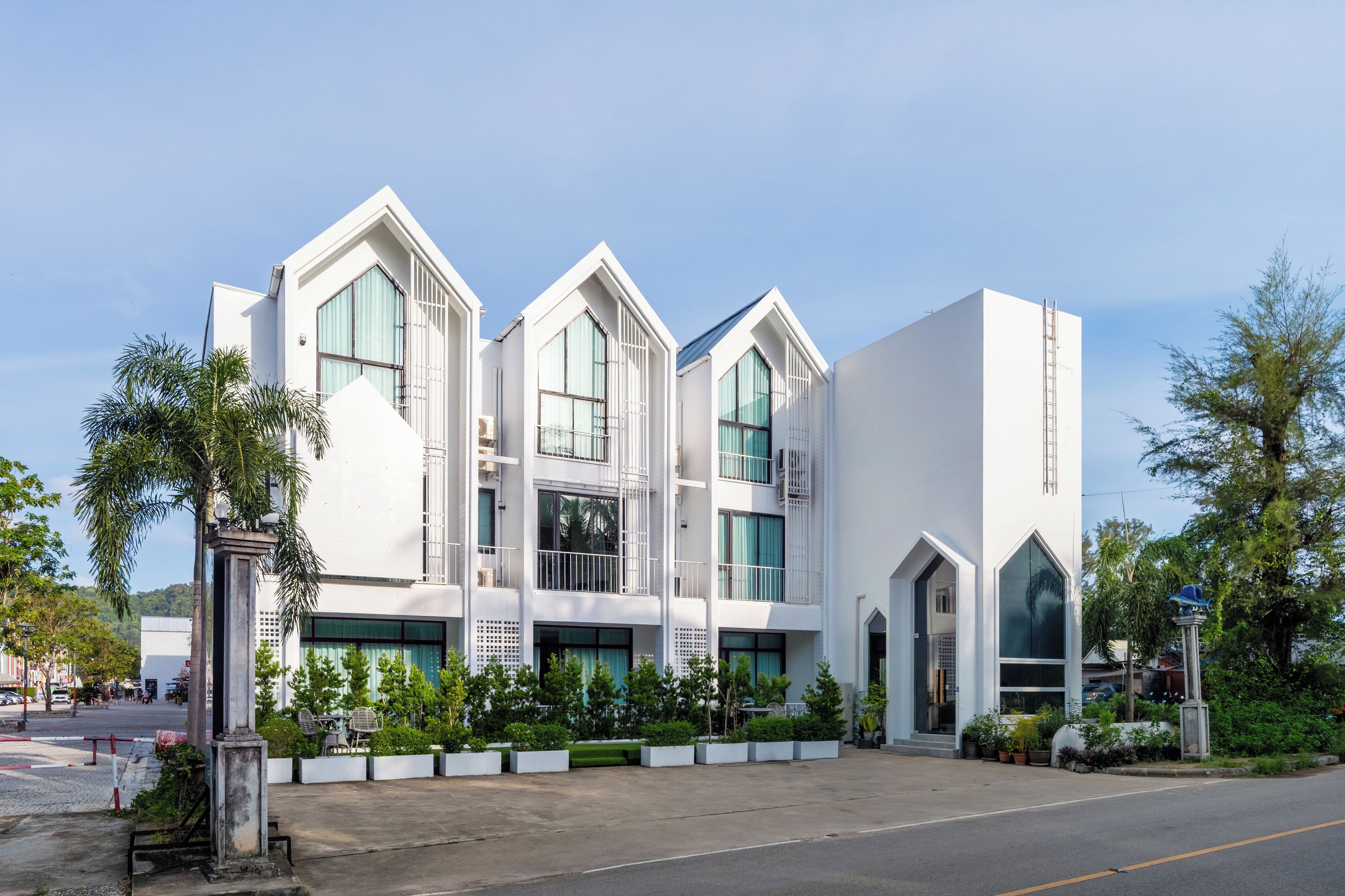 A modern building with a symmetrical facade, large windows, and a gated entrance.