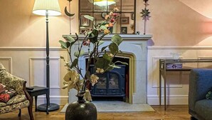 A living room with a glass coffee table, a sofa, a fireplace, and a mirror. - Luxury Cottage in the Heart of Bath (Bath)