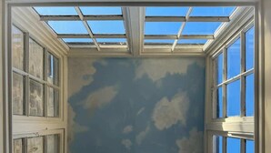 A room with a skylight and multiple windows, providing natural light and views of the sky. - Luxury Cottage in the Heart of Bath (Bath)