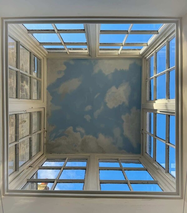 A room with a skylight and multiple windows, providing natural light and views of the sky.