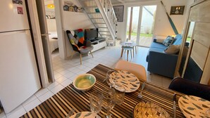 A modern living room with a dining area, a staircase, and a view of the outdoors. - CALLEA II - Holiday home with garden in Carnac - K16 (Carnac)