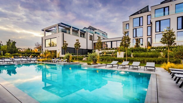 A modern hotel with a swimming pool, lounge chairs, and a well-maintained garden. - Therma Numera Longevity SPA (Burgas)