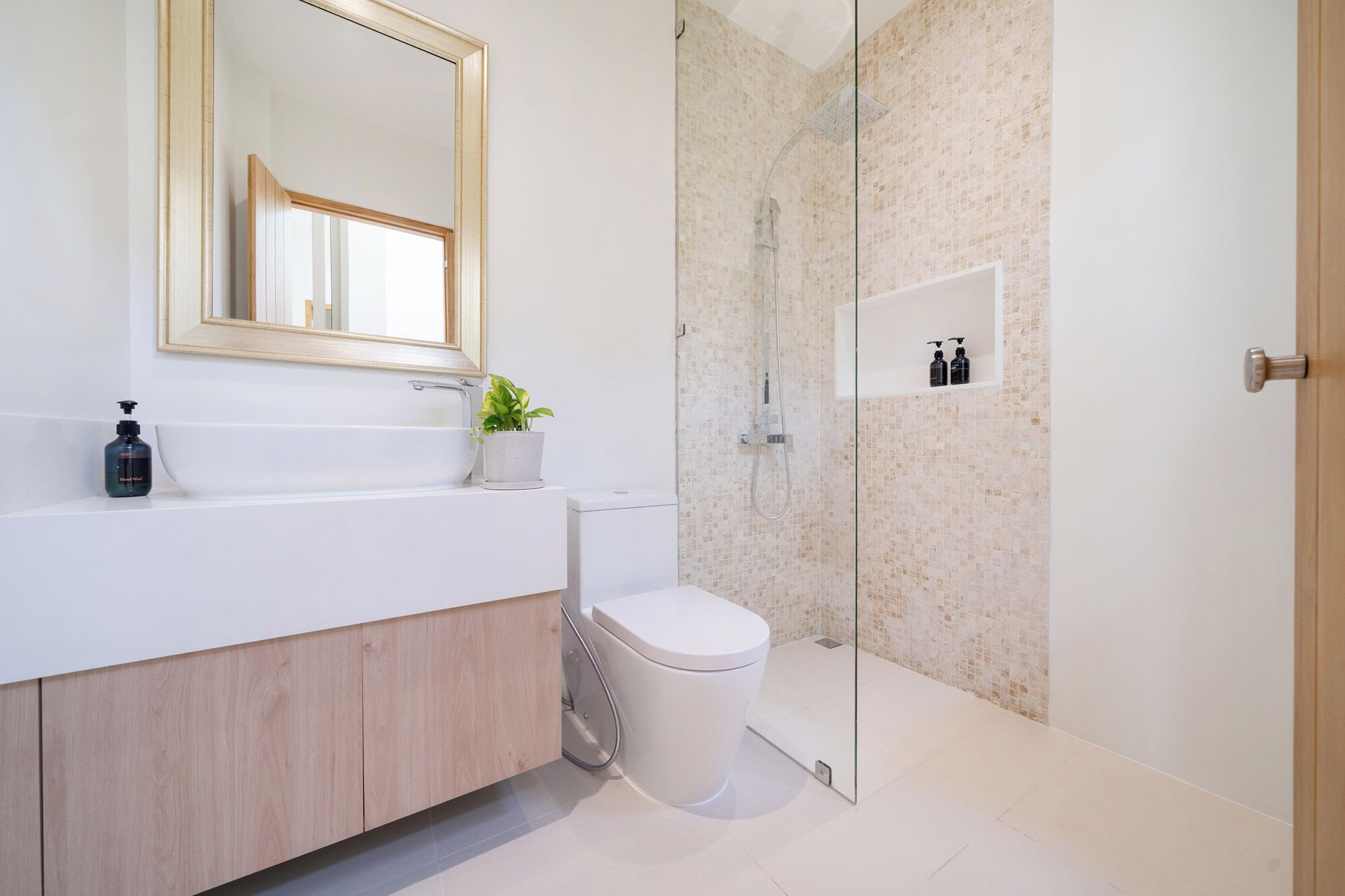 Un bany modern amb un moble de bany blanc, una cabina de dutxa de vidre i un lavabo.