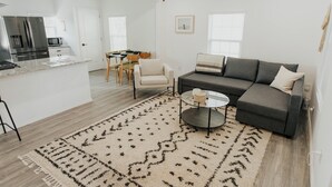 A modern apartment with a kitchen, dining area, and living room.