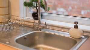 A kitchen sink with a faucet, a dish rack, and a soap dispenser.