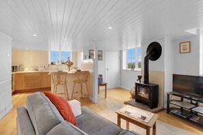 Ett modernt vardagsrum med en soffa, ett TV-bord och en öppen spis.