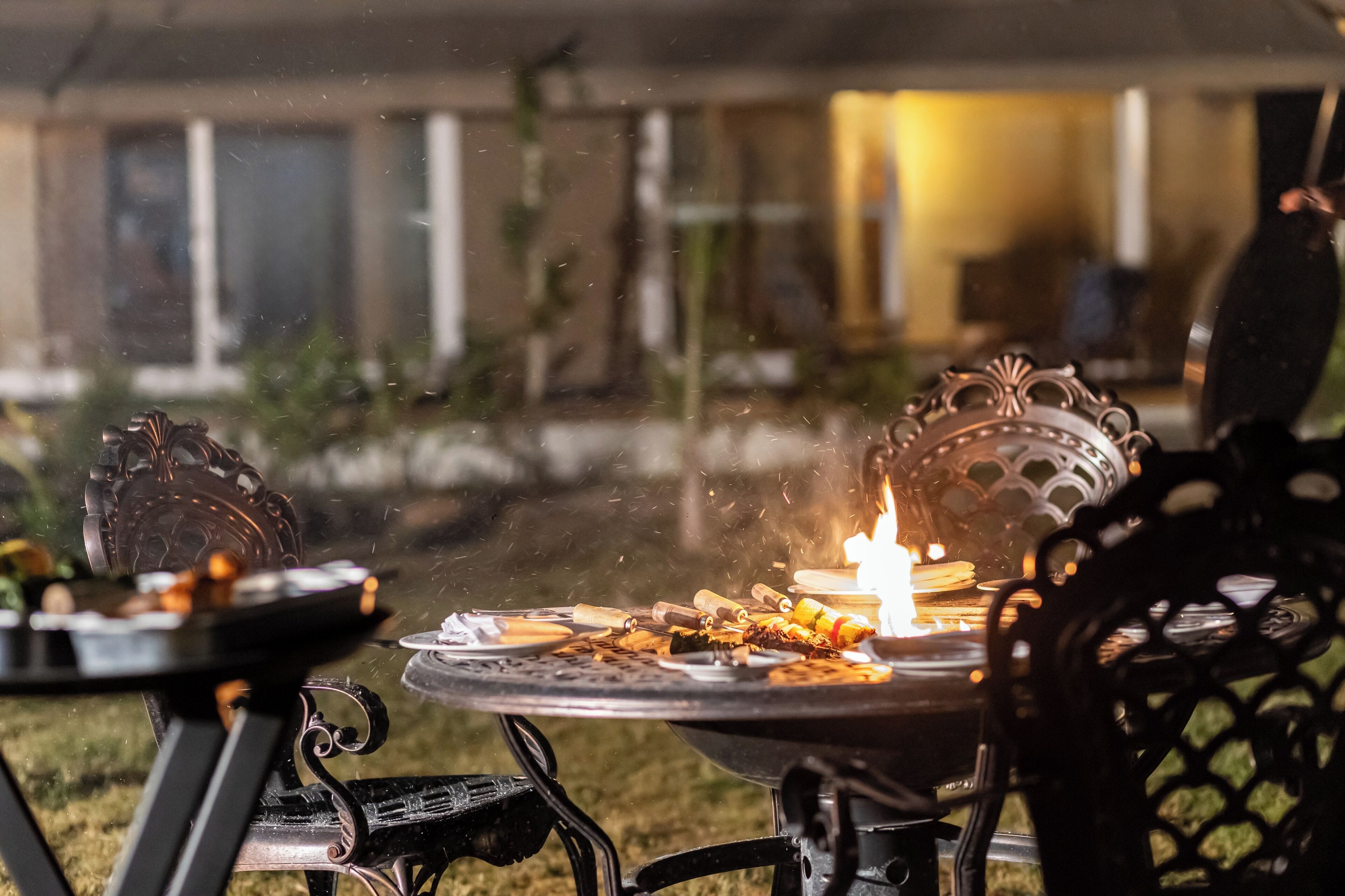 Un espace extérieur aménagé pour les repas, avec un barbecue et des chaises.