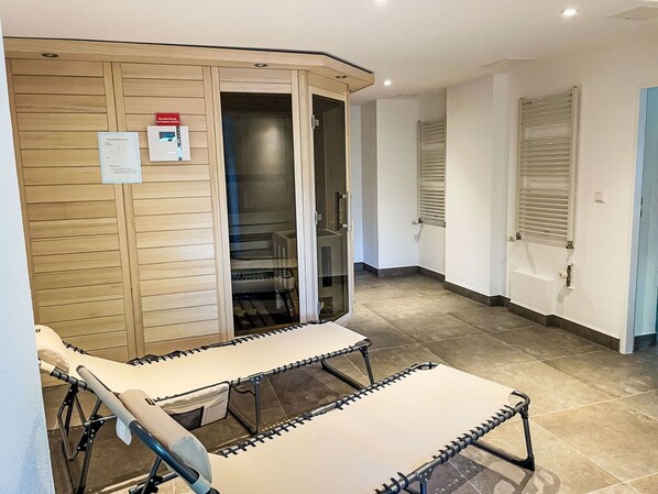 A room with a wooden wardrobe, a glass door leading to a bathroom, and a bed with a headboard. - Lovely apartment for 4 guests with WIFI, TV, balcony and pets allowed (Sassnitz)