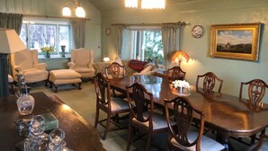 A dining area with a wooden table, chairs, and a chandelier. There are windows with curtains and a painting on the wall. - Beautiful private villa for 10 people with WIFI, TV, terrace, pets allowed and panoramic view (Inverness)