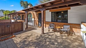A patio area with a pergola, outdoor seating, and a brick wall. - Elegant Green Valley Villa 55+ (Green Valley)