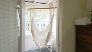 A doorway leading to a porch with a white chair and a hammock. - 28 Morris - Classic, centrally located cottage in Chautauqua Institution! (Chautauqua)