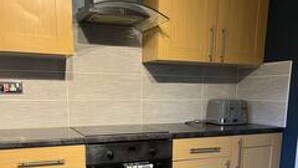 A kitchen with wooden cabinets, a black oven, and a microwave.