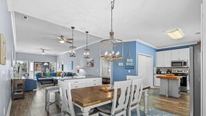 A spacious kitchen with a central island, white cabinetry, and a blue accent wall. - 4 bedroom 3 bath home in Cherry Grove. Screened porch Firepit. 2 blocks to ocean (North Myrtle Beach)
