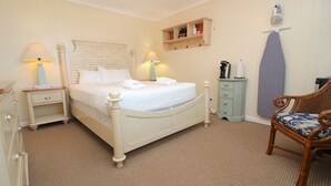 A neatly arranged bedroom with a bed, bedside tables, a chair, and a wardrobe. - Wren Watch 1 Queen Regular Fin N Feather (Nags Head)