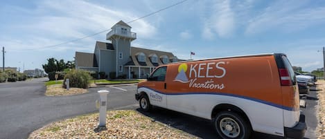 A KEES Vacations van parked in front of a residential building with a unique multi-level design.