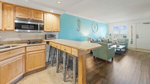 A modern kitchen with wooden cabinets, a stainless steel range hood, and a built-in microwave. - Relaxing Ocean Wynnes at Villas of Hatteras Landing - 1 Bedroom Near-Beach Condos with Pool Access! (Hatteras)