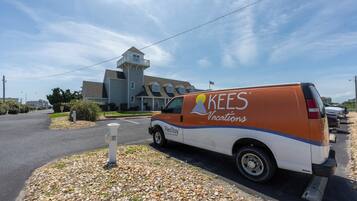 A KEES Vacations van parked in front of a residential building with a unique multi-level design.