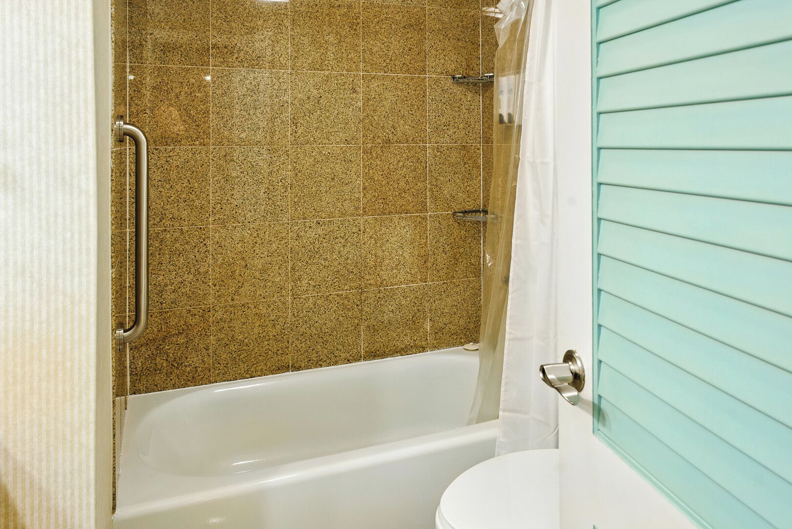 A bathroom with a bathtub, a toilet, and a shower curtain.