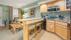 A kitchen with wooden cabinets, a granite countertop, and stainless steel appliances.