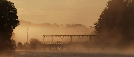 Un ponte che scavalca uno specchio d'acqua avvolto dalla nebbia.
