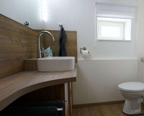 Een douche, een haardroger, handdoeken, toiletpapier