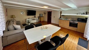 A compact living space with a dining area, kitchenette, and a sofa. - 2-room apartment in prime city center location with terrace & DreiWelten-Card (Bad Dürrheim)