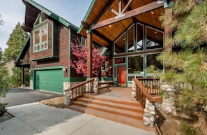 A wooden house with a green garage, a porch with stone steps, and a large window. - Handels Pride- Family friendly, Game Room & Views (Shaver Lake)
