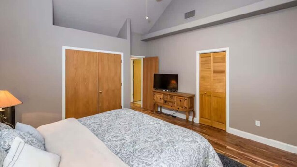 A bedroom with a bed, a wooden wardrobe, a television, and a ceiling fan. - Handels Pride- Family friendly, Game Room & Views (Shaver Lake)