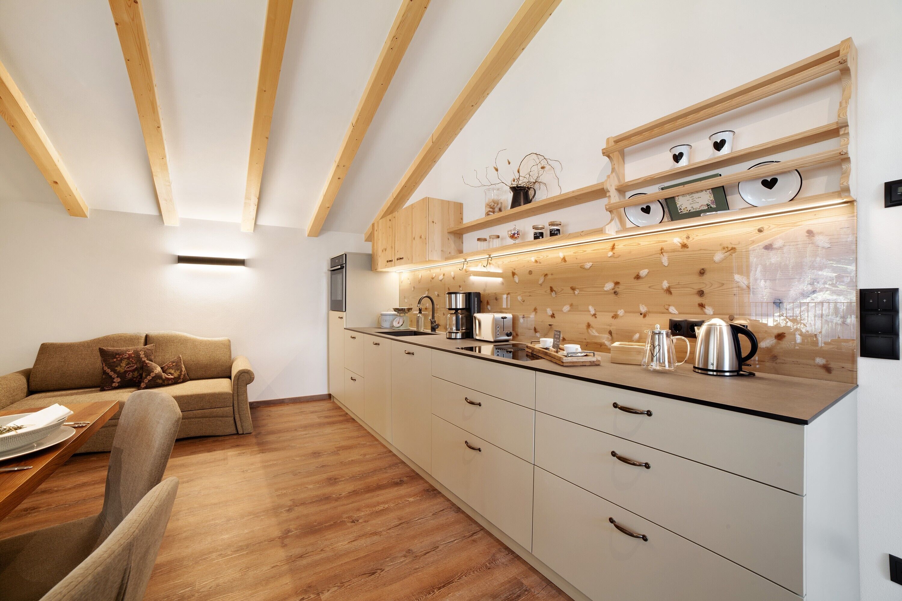 Een moderne keuken met houten balken, een inbouwoven en een aanrecht met diverse apparaten.
