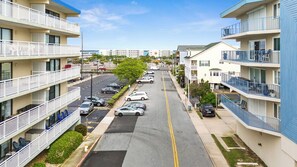 A multi-story parking lot with cars parked in rows, surrounded by buildings with balconies and a clear sky. - Spacious 3-Bedroom Ocean Block Townhome – Steps from the Sand! (Ocean City)