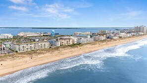 A coastal cityscape with a beachfront hotel, a water tower, and a pier in the background. - Spacious 3-Bedroom Ocean Block Townhome – Steps from the Sand! (Ocean City)